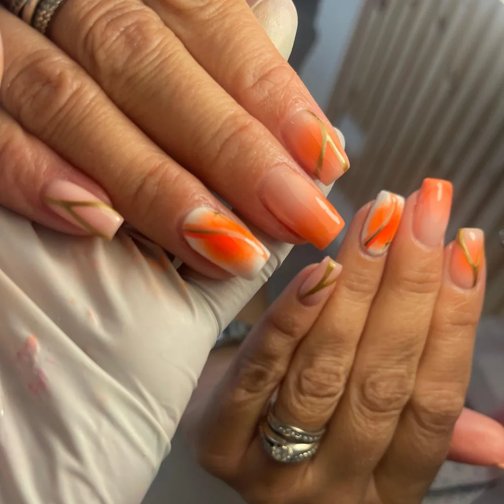 BIAB nails finished with an orange abstract design
