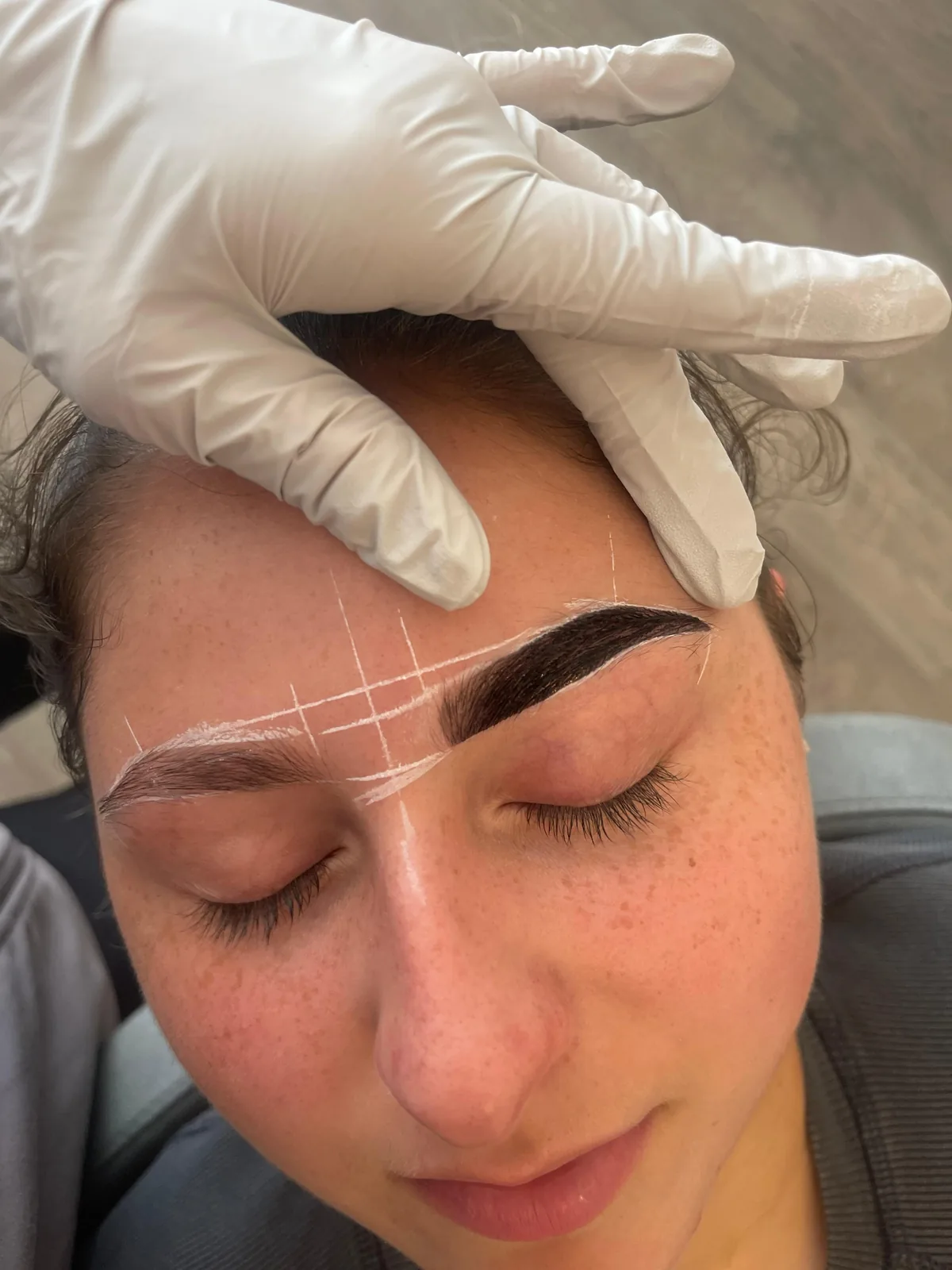 Guide lines mapped onto a client's brows before lamination