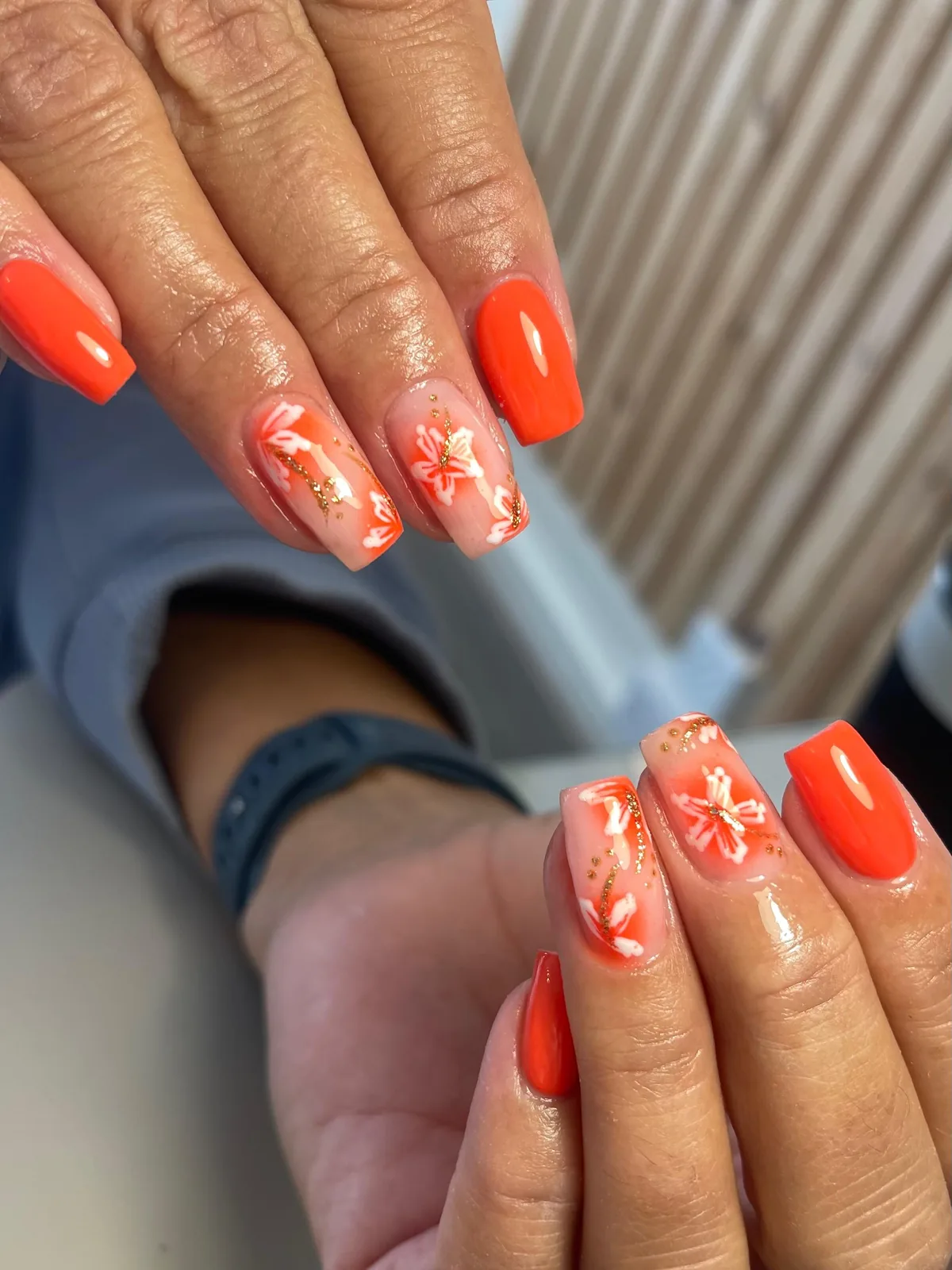 Orange BIAB nails with hand-painted white florals and gold detailing
